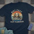Navy blue t-shirt with a graphic of a sloth playing chess and 'Not Fast Not Furious' text on a stone surface.